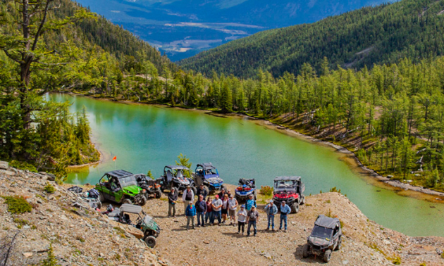 The Kootenay Rockies ATV Club poses in front of a small lake outside of Cranbrook