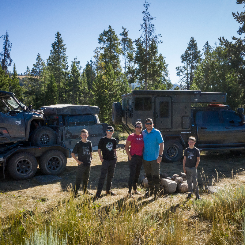 (L to R) Ryder, Cyrus, Rachelle, Clay and Eli Croft stand in front of their Dodge Ram 3500, carrying a Patriot Camper TH610 trailer with a Polaris General 1000.