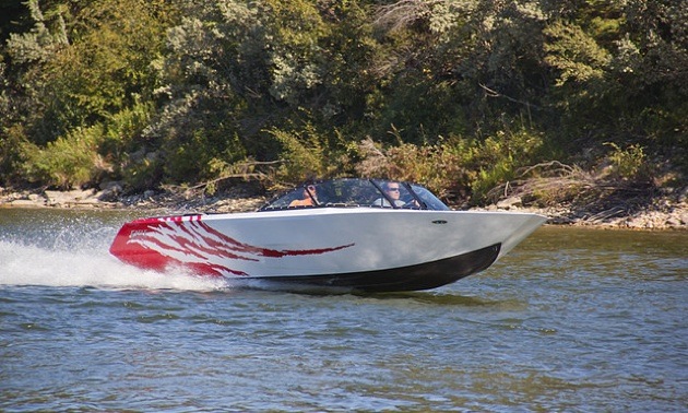 A speed boat ripping along the river.