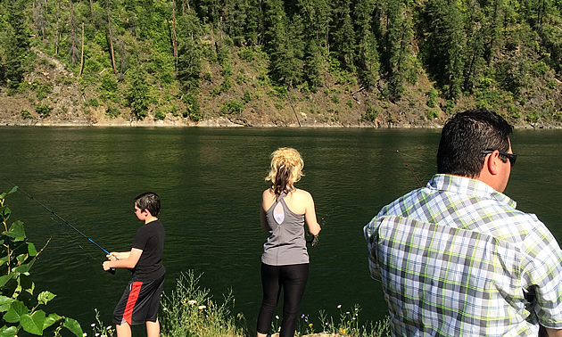 Eric Buckley, Nicole Lind and Will Buckley standing on a rock and fishing the Pend d'Oreille River in British Columbia