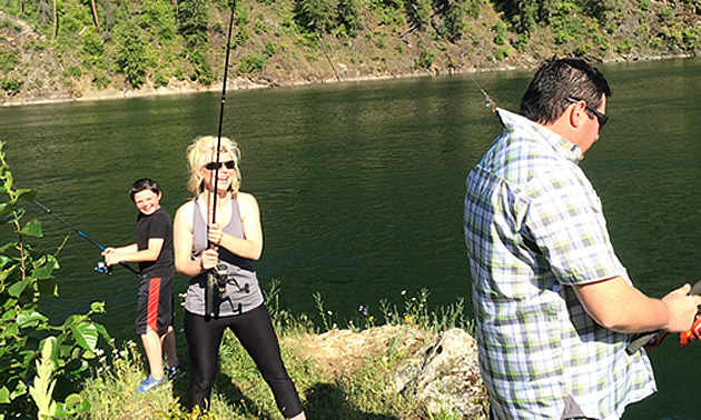 Eric Buckley, Nicole Lind and Will Buckley fishing the Pend d'Oreille River while Nicole's lure hooked the collar of Will's shirt