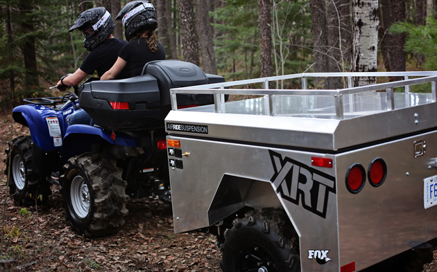 An aluminum trailer pulled behind an ATV. 