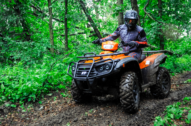 A group of riders coming up a trail on the new Argo four wheelers. 