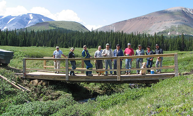 A group of people standing on a bridge. 
