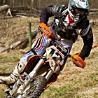 A guy leaning into a corner riding a dirt bike
