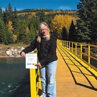Woman standing on a wooden bridge over a river in the backcountry