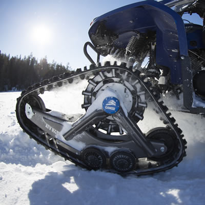 A smaller ATV with a track system in the snow. 