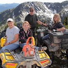 People sitting on ATVs at a mountain location