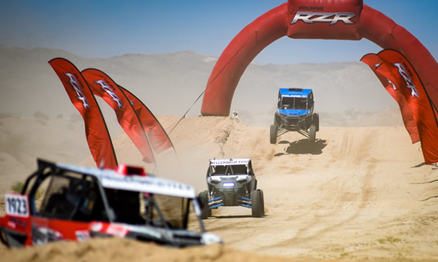 Pictured are several UTVs racing in the desert.