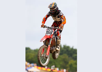 photo of a guy flying through the air on a dirt bike. 