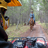 An ATVer approaching a horseback rider. 