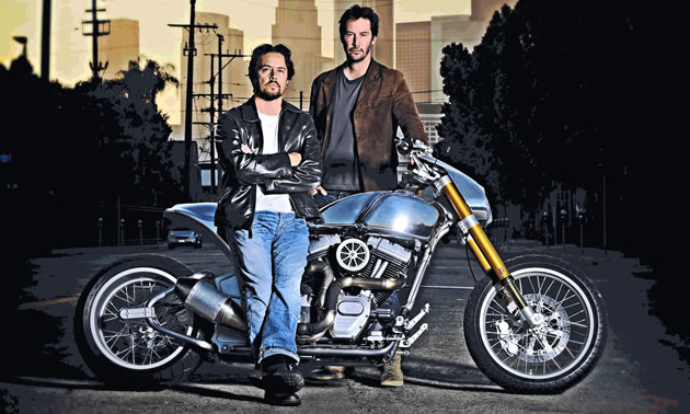 Gard Hollinger and Keanu Reeves pose in front of and behind a KRGT-1 motorcycle.