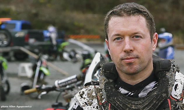 A brown haired man in dirt bike riding gear. 