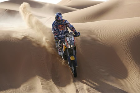 Kurt Caselli racing over a sand dune on his KTM. 