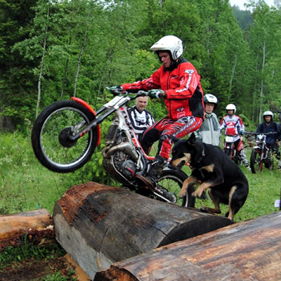 Sam King wheelieing over some logs. 
