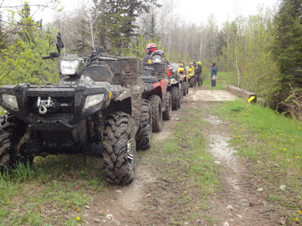 ATVs lined up behind each other on a path