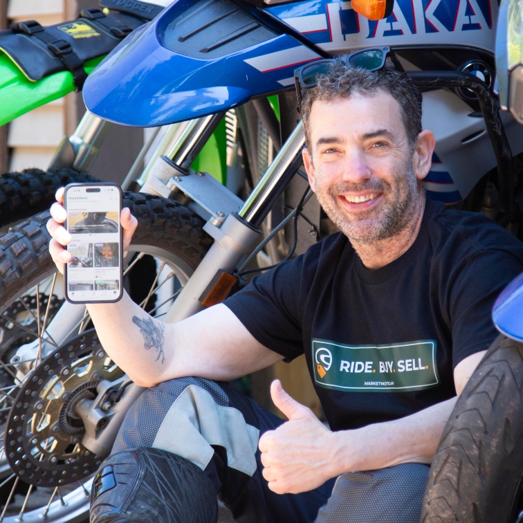 Matt Greenberg holding his phone up to show the MarketMoto app