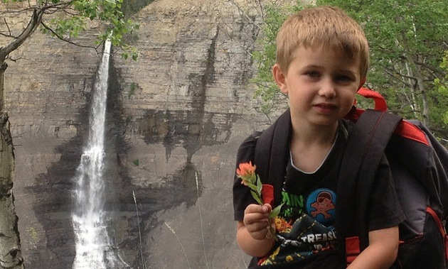 6 year old Mason Court sitting in front of waterfalls. 