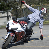 A guy hanging off the side of a streetbike. 