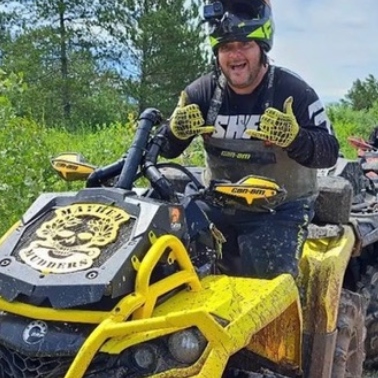 Mike on a yellow ATV giving a thumbs up