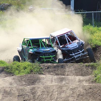 Close racing action with two UTVs. 