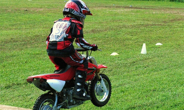 A young boy riding a motorcycle.