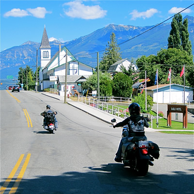 Two motorcyclists riding through Kaslo. 