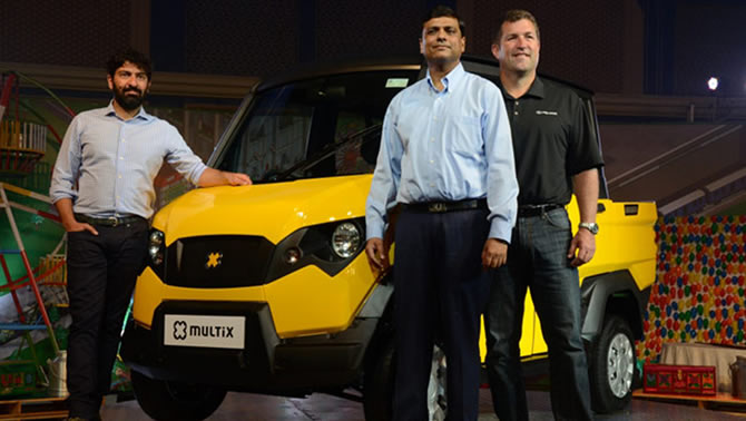 Picture showing 3 men standing in front of the Multix, a yellow and black personal utility vehicle. 