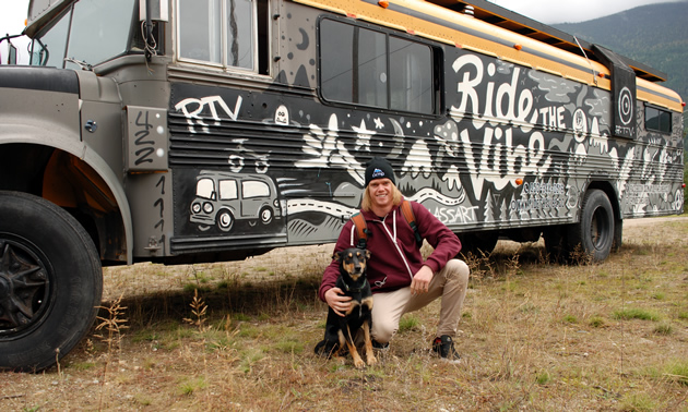 Sam King and his dog, Tiki, in front of a school bus. 