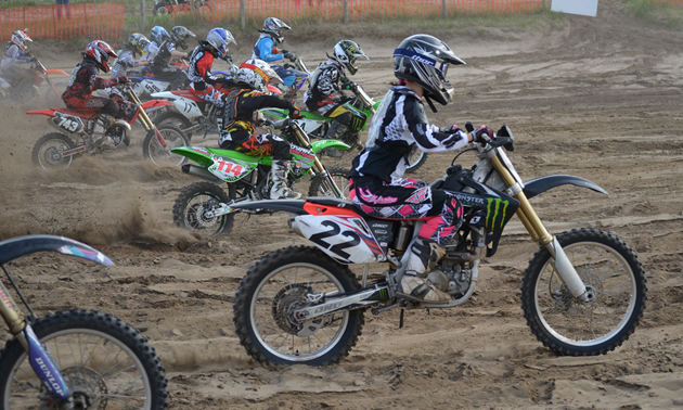 Dirt bike racers coming off the start line. 