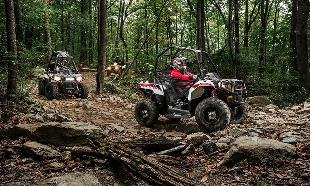 Photo of two Polaris Sprtsman Ace on a backcountry trail.