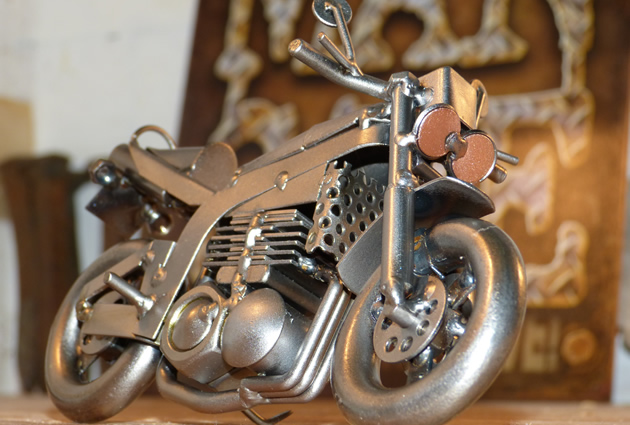 A metal motorcycle figuring with a man cave sign in the back. 