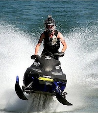 Taylor Fisk riding a snowmobile on water.