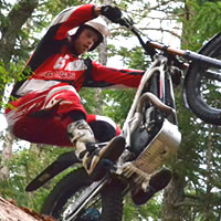 View from the ground up of a man riding a trials bike. 