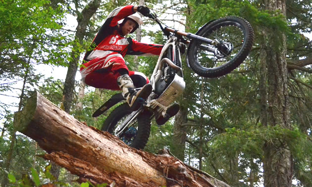 View from the ground up of a man riding a trials bike. 