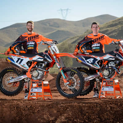 Kaven Benoit and Cole Thompson standing beside their orange KTMs. 
