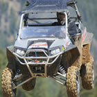 Photo of a guy in a UTV flying through the air. 