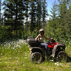 Woman on an ATV in the forest.