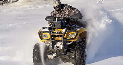 Person riding ATV through snow