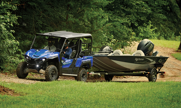 Yamaha Wolverine X4 in blue towing a fishing boat. 